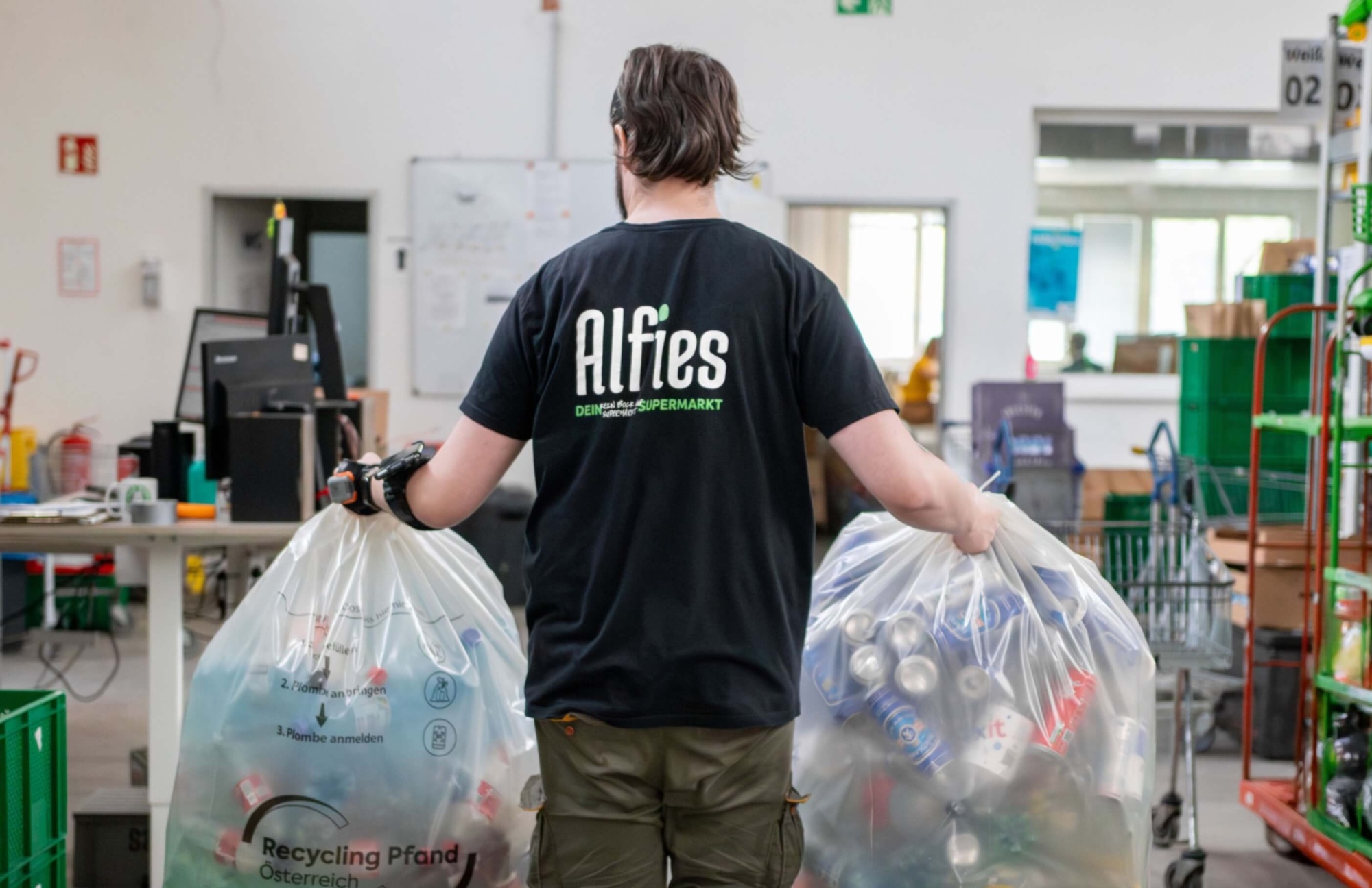 Alfies Mitarbeiter trägt Pfandflaschen