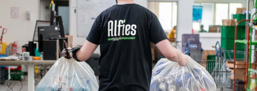 Alfies Mitarbeiter trägt Pfandflaschen