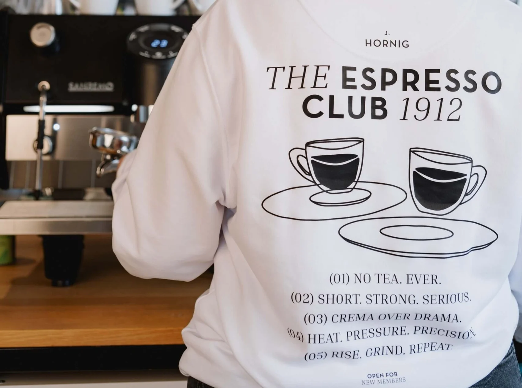 Kaffee ist für viele längst mehr als ein Wachmacher. Er ist Ritual, Lifestyle und in seinen unzähligen Variationen oft auch Ausdruck der eigenen Persönlichkeit. Genau dieses Gefühl greift J. Hornig mit ihrer „Espresso Club“ Kollektion auf. Ab 1. April startet die zweiwöchige Pre-Order-Phase der neuen Kollektion, die aus Sweatshirts, T-Shirts und Tote Bags in zwei verschiedenen Designs besteht. Und anders, als es das Datum vielleicht vermuten lässt, handelt es sich hierbei nicht um einen April-Scherz.